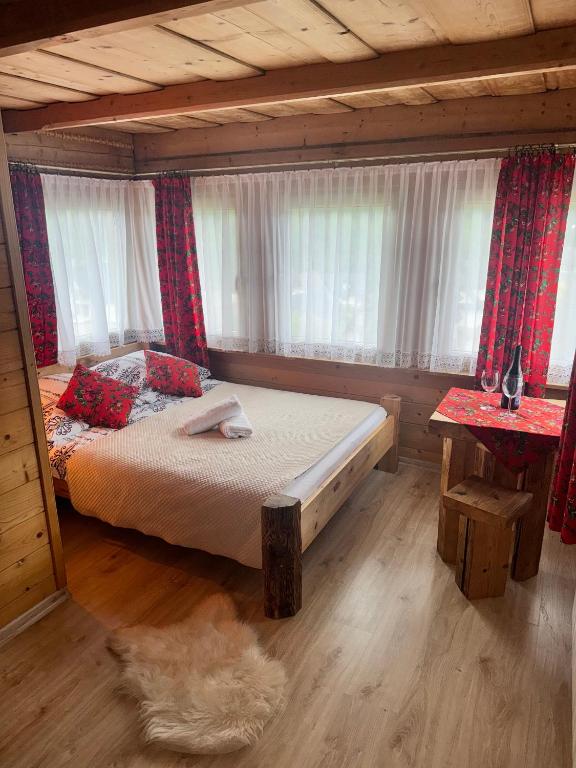 a bedroom with a bed in a log cabin at U Młynorza Jacuzzi ogrodowe całoroczne in Suche