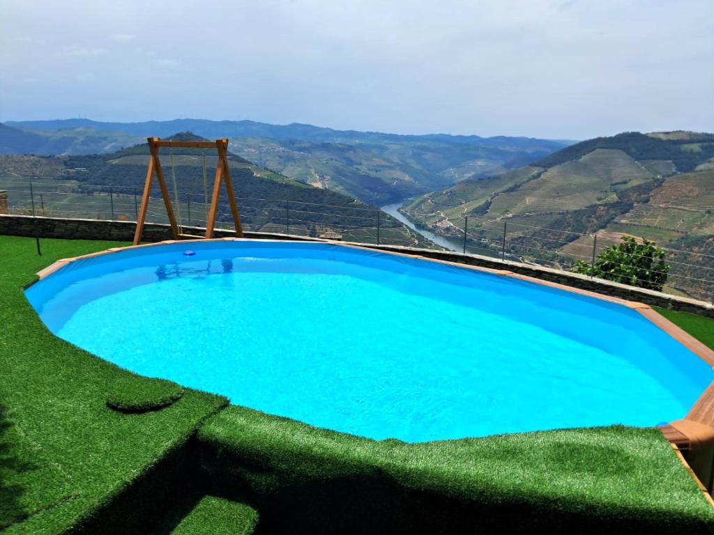 a large blue swimming pool with a view of mountains at Riba Loivos Village - Casa C - T3 in Casal de Loivos