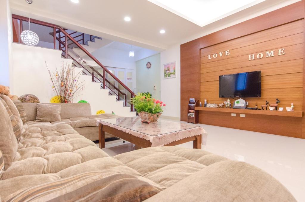 a living room with couches and a tv at Happy House Homestay in Hualien City