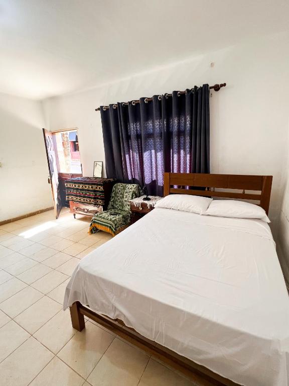 a bedroom with a bed and a chair at Estudio Privado en Samaipata in Samaipata
