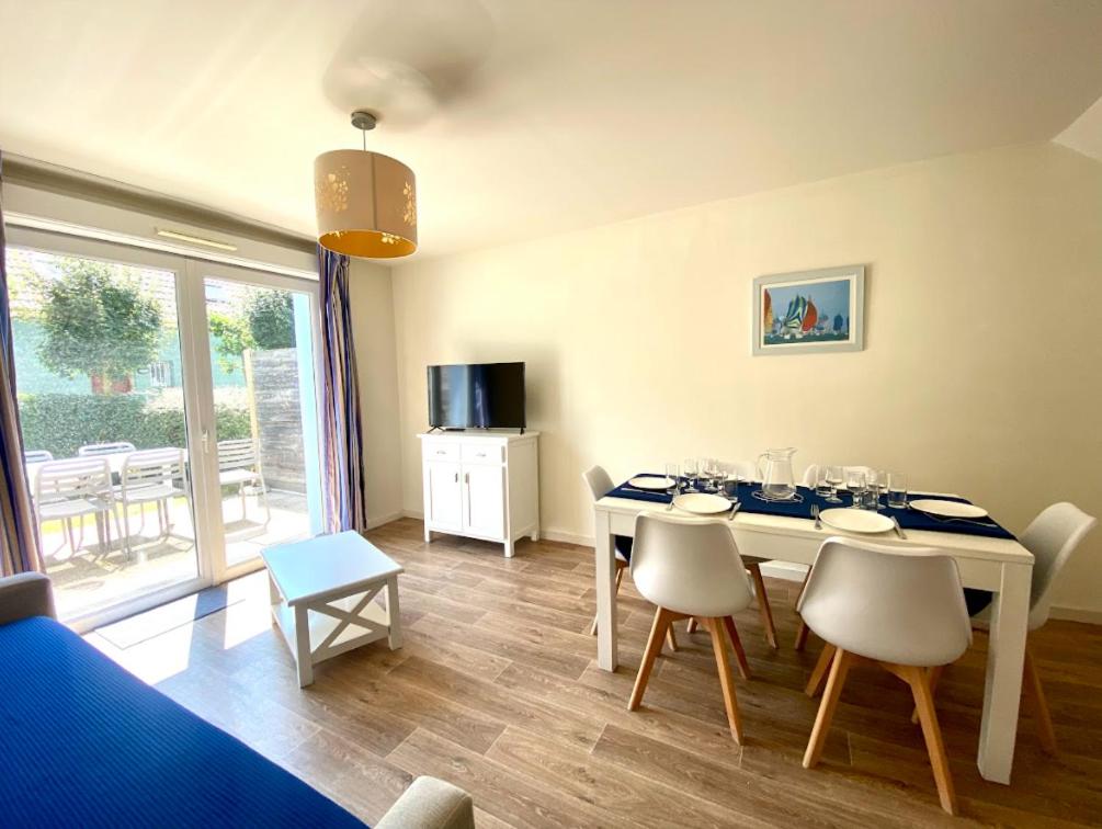 un salon avec une table et des chaises de salle à manger dans l'établissement La villa Astrid - 2 chambres - piscine - mer - parking, au Crotoy