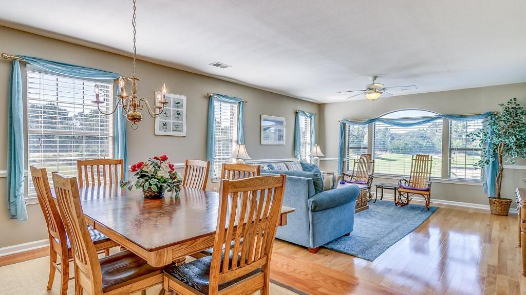 a dining room with a table and a blue couch at 57C Fifty-Seven Sea at True Blue condo by Peace Vacations in Pawleys Island