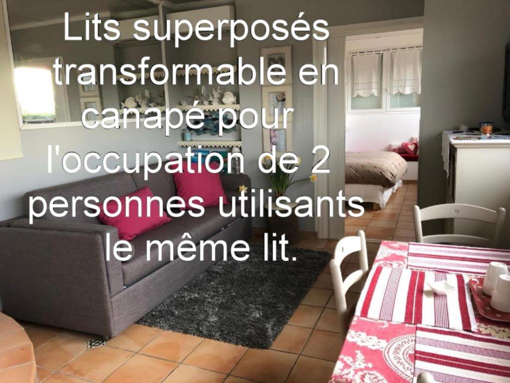 ein Wohnzimmer mit einem Bett und einem Tisch in der Unterkunft Les Grimaldines - Maison d&#39;Hôtes in Cagnes-sur-Mer