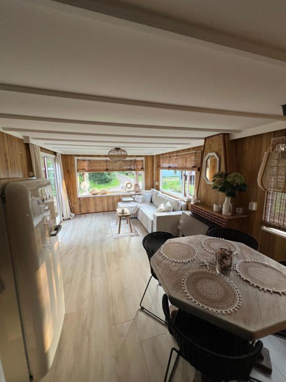 a living room with a table and a couch at Ibiza style chalet in Eext