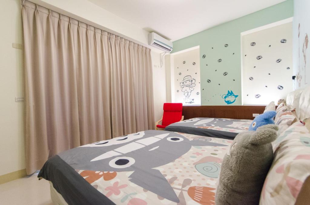 a bedroom with two beds with a hello kitty blanket at Happy House Homestay in Hualien City
