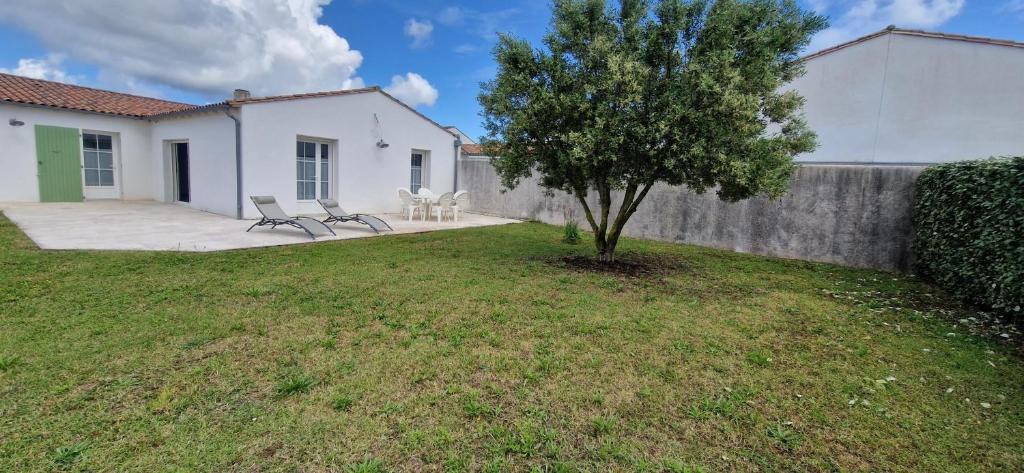 a yard with two benches and a tree at Maison du Chai in Sainte-Marie-de-Ré