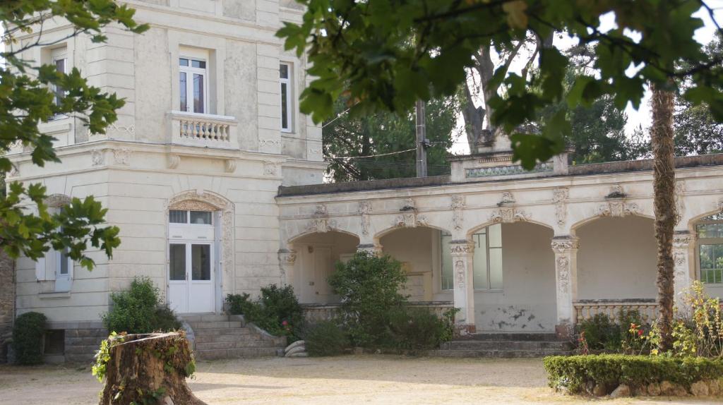 un grand bâtiment blanc avec des arbres devant lui dans l'établissement Villa Rosa, à Pornichet
