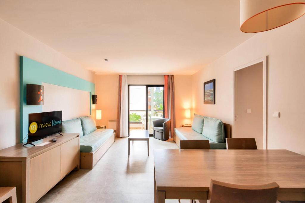 un salon avec un canapé et une table dans l'établissement Résidence L'Archipel - maeva Home - Appartement vue mer 3 pièces 6 personnes - Prestige MAE-6251, à Perros-Guirec