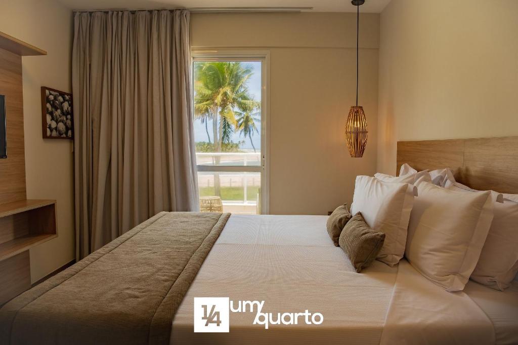 a bedroom with a large bed with a window at Ponta de Inhambupe Residences in Baixio