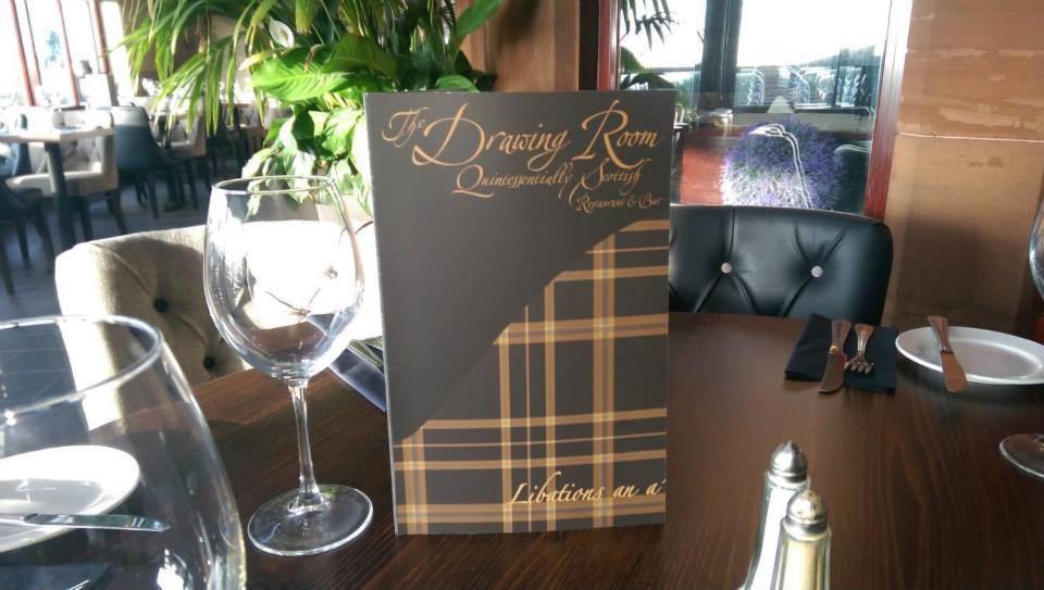 een bord op een tafel met een wijnglas bij Lauriston Hotel in Ardrossan