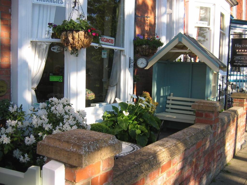 un banc devant un bâtiment fleuri dans l'établissement Binton Guest House, à Filey