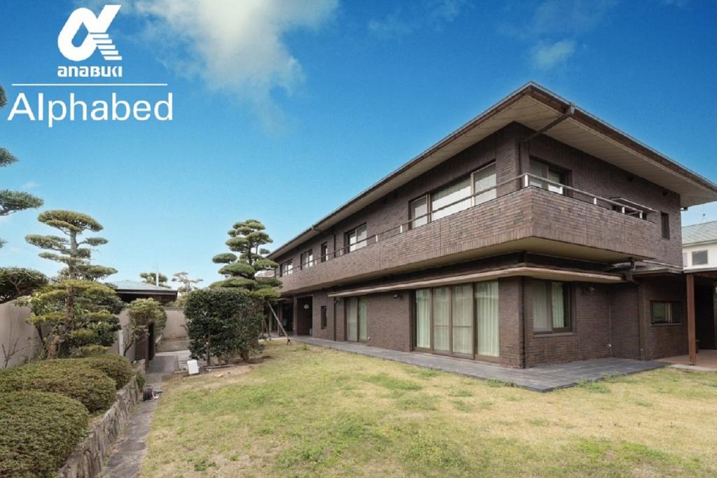 ein großes Backsteinhaus mit Hof in der Unterkunft Alphabed Villa Waka - Vacation STAY 17109 in Takamatsu
