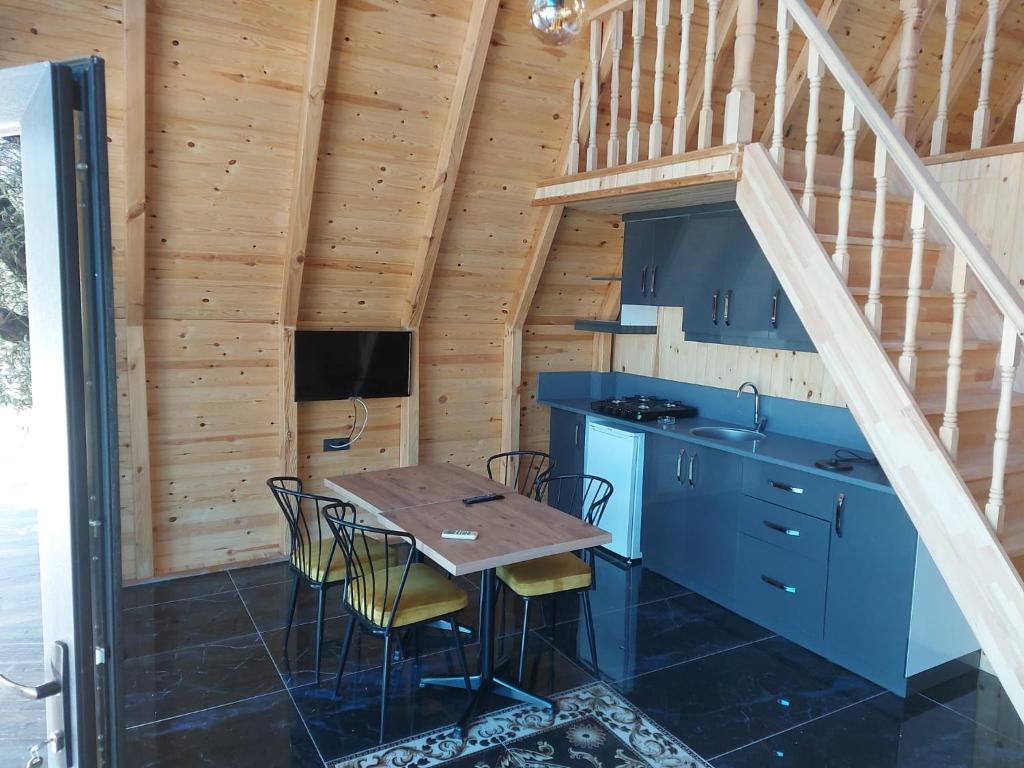 a kitchen with a table and chairs in a cabin at Çırağan Deluxe BOTANİK Park Bungalov Evleri in Tire