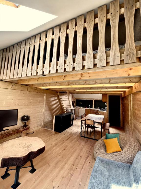 un salon avec parquet et escalier en bois dans l'établissement L'Ostal, à Les Combes
