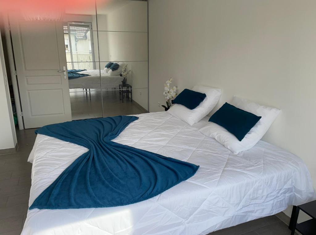 - un grand lit blanc avec une couverture bleue dans l'établissement F2 56m2 - Arena Gd Paris - Parc des expositions Villepinte - Aéroport Paris CDG, à Villepinte