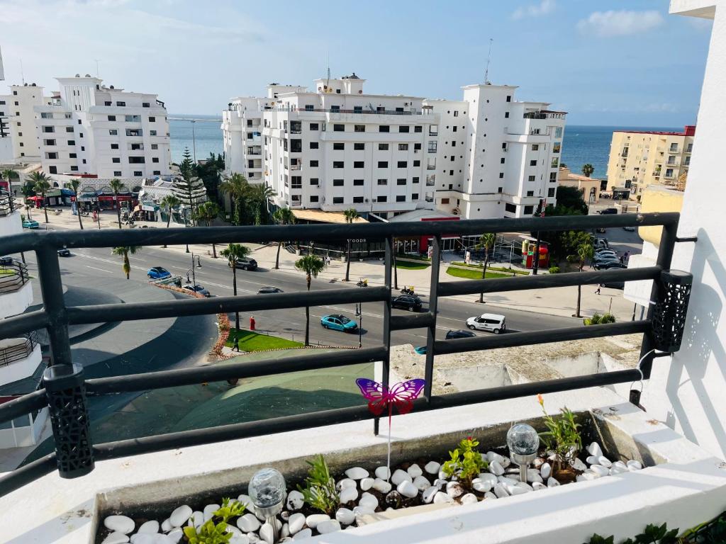 a balcony with a view of a street and buildings at Bright Apartment with Sea View, few steps away from the TGV in Tangier