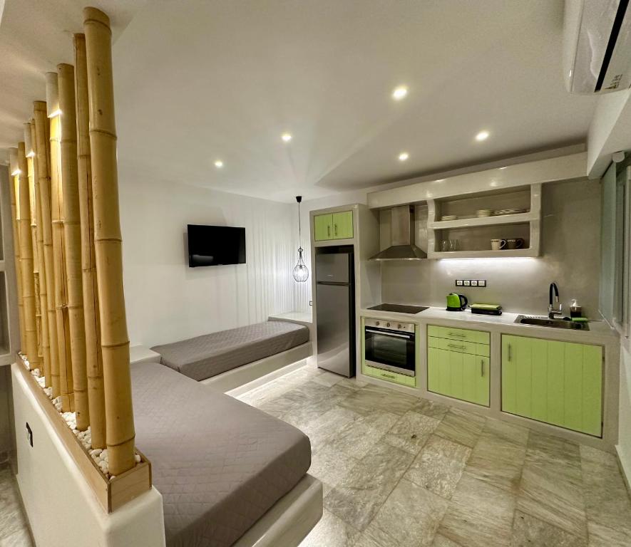 kuchnia z zielonymi szafkami i kuchenką górny piekarnik w obiekcie Aphrodite Hotel & Apartments w mieście Ios (Chora)