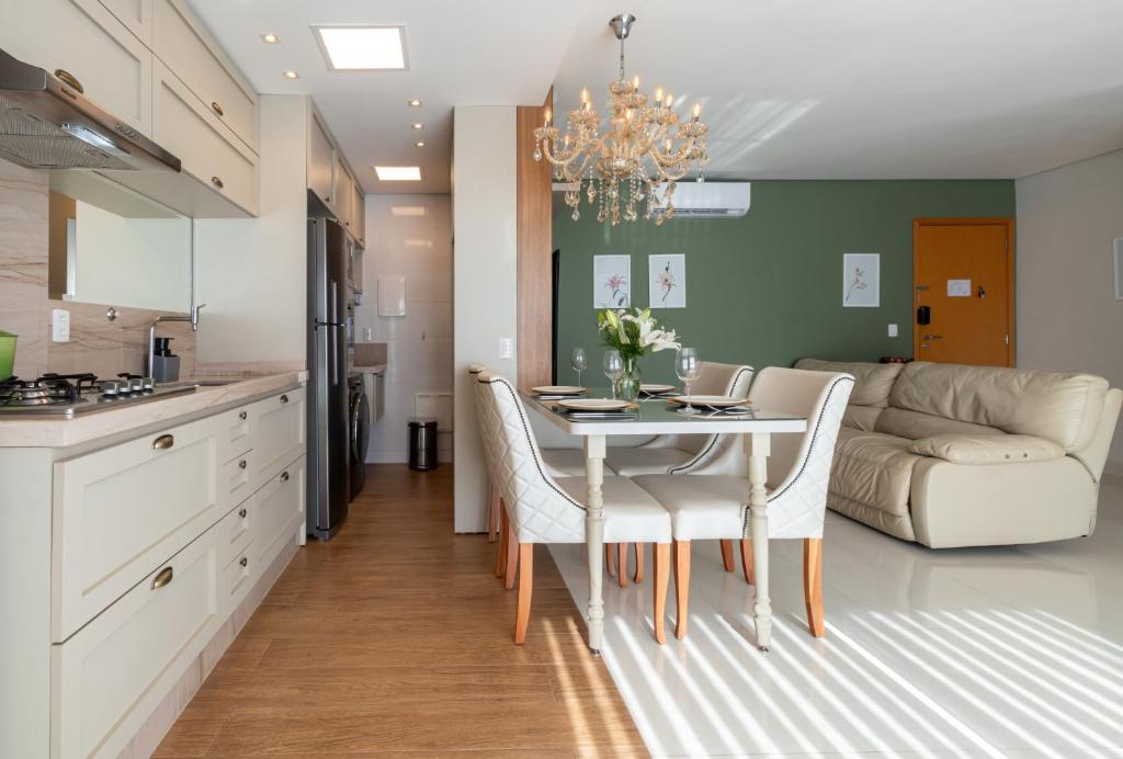 a kitchen and living room with a table and chairs at PALMAS EXPERIENCE - Apartamento Luxuoso, vista lago, próximo ao shopping in Palmas