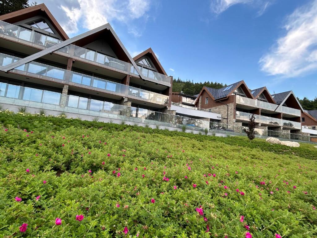 une vue extérieure d'un bâtiment avec un champ de fleurs dans l'établissement Kras Resort 304 Szklarska Poręba, à Szklarska Poręba