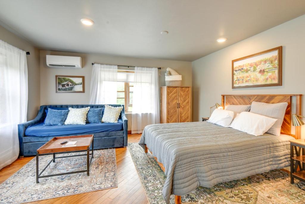 a bedroom with a bed and a blue couch at Meredith Studio Near Downtown Hike, Swim, Ski! in Meredith