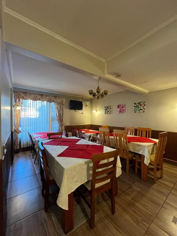a dining room with tables and chairs and a television at Hotel Santa Sofia in Concepción