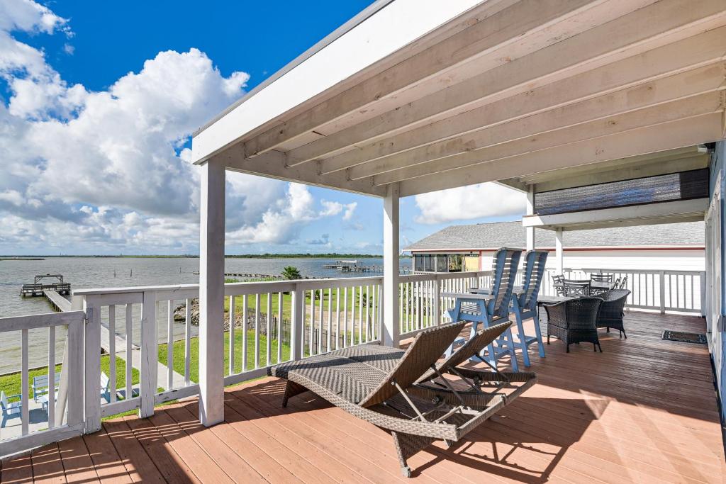 a deck with chairs and a table and a view of the water at On Galveston Bay Spacious Home with Pier and Grills! in San Leon