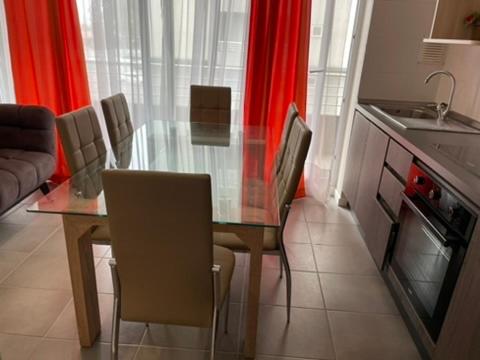 Una cocina con una mesa de cristal y sillas en una habitación. en Departamento Alto Serena V, en La Serena