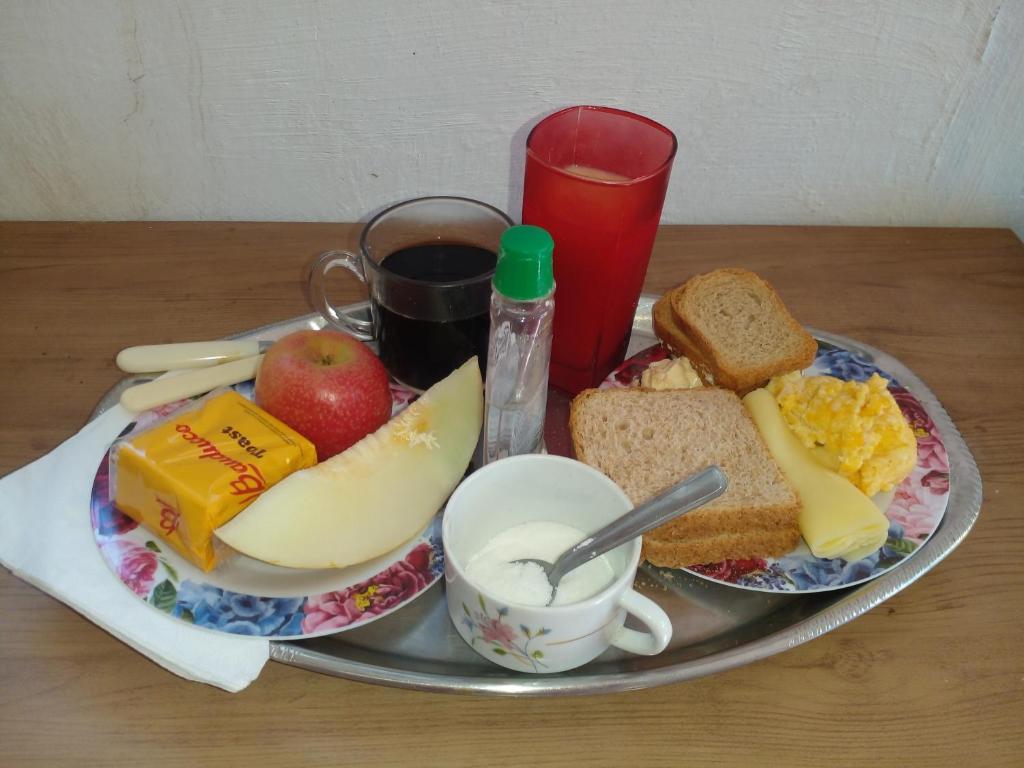a tray of food with bread and fruit on a table at Hospedaria Guapê in Lauro de Freitas