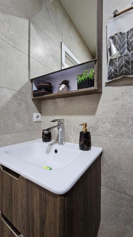 a bathroom with a white sink and a mirror at Superb 1 bedroom in the best zone of the city. in Ferizaj