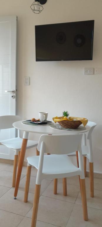 a white table and chairs with a plate of food on it at Los Paraísos Oro Verde in Oro Verde