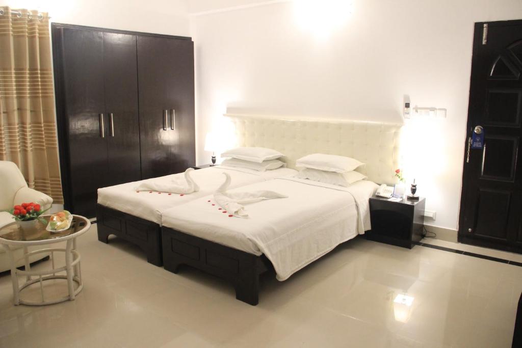 1 dormitorio con 1 cama grande y 1 mesa en Aristocrat Inn en Dhaka