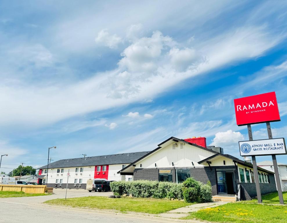 una señal roja frente a un edificio blanco en Ramada by Wyndham Dawson Creek, en Dawson Creek