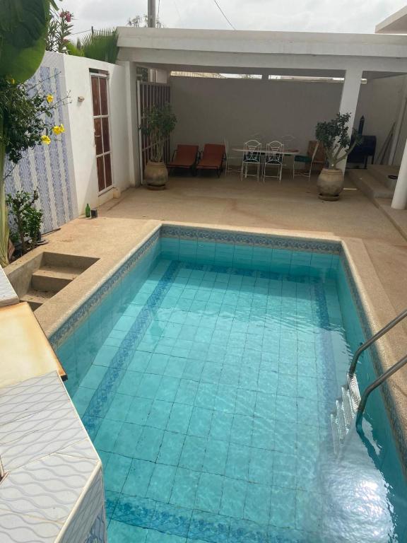 a swimming pool with blue water in a backyard at Villa 3 patios in Somone