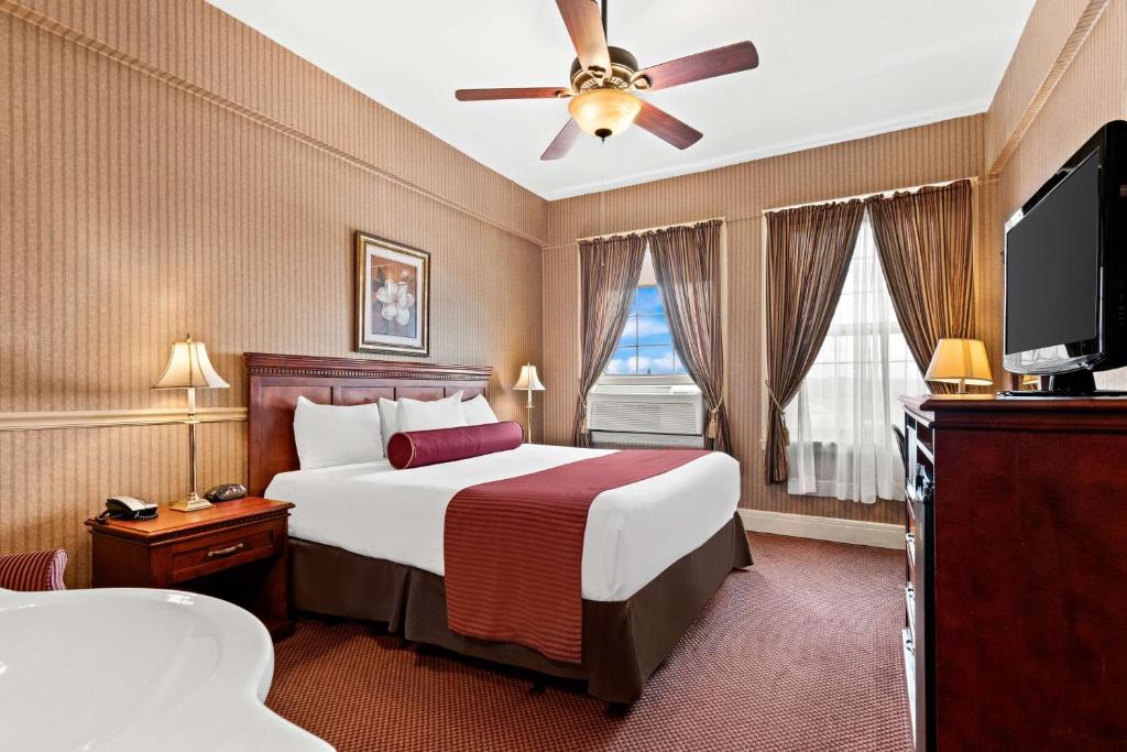 a hotel room with a bed and a flat screen tv at Genetti Hotel, SureStay Collection by Best Western in Williamsport