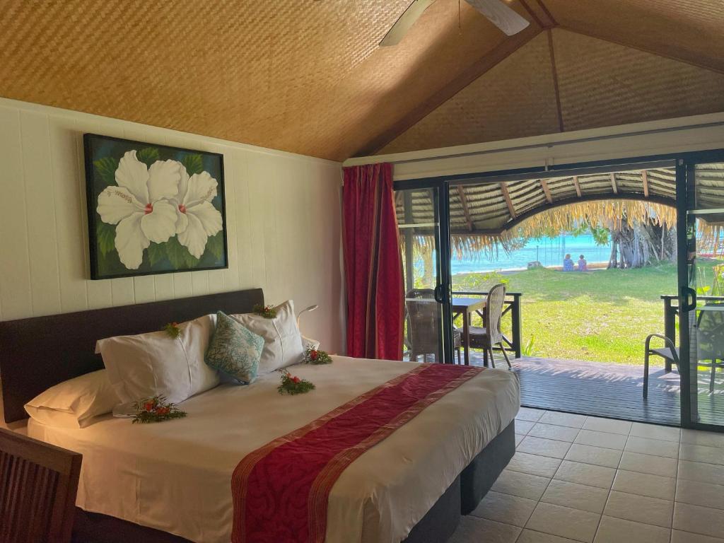 um quarto com uma cama e vista para um pátio em Hotel Hibiscus em Papetoai
