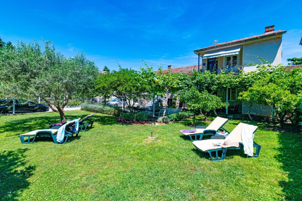 a group of lawn chairs sitting in the grass at Apartments with parking space Fazana - 18334 in Fažana