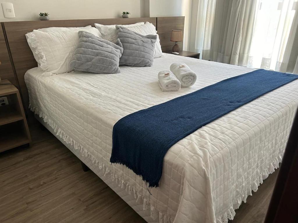 a bedroom with a large bed with towels on it at Aconchegante Flat Premiere Rio Centro in Rio de Janeiro