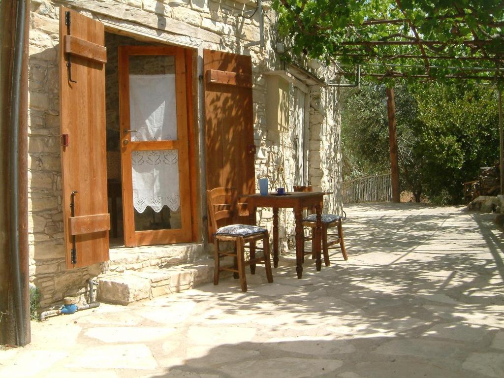 une table et des chaises assises à l'extérieur d'une maison dans l'établissement Eleni's Cottage, à Apsiou