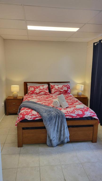a bedroom with a bed with a red comforter at The Gabba B&B in Brisbane