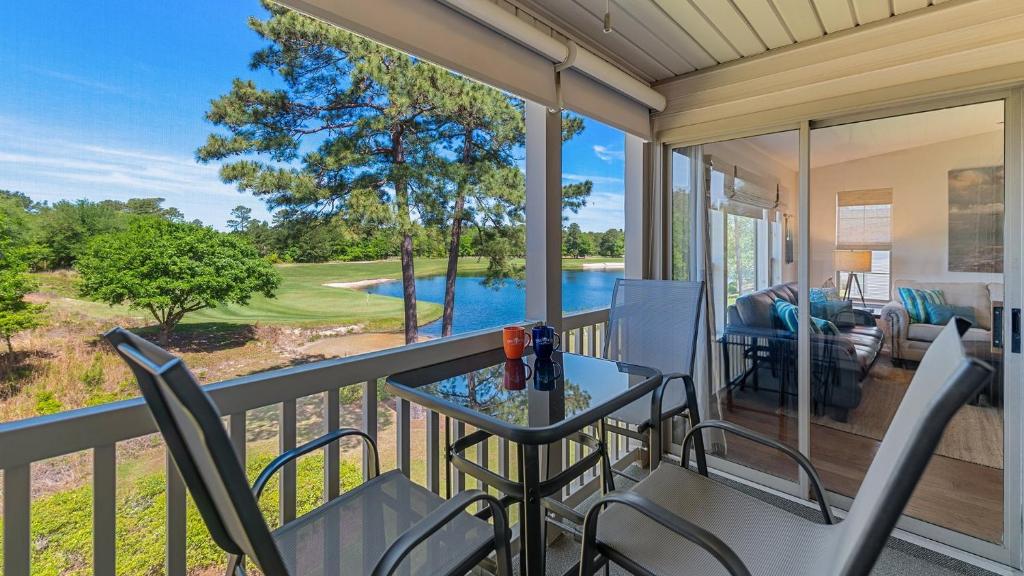 a balcony with a table and chairs and a view of a pool at 55F Pawleys After Dark condo by Peace Vacations in Pawleys Island