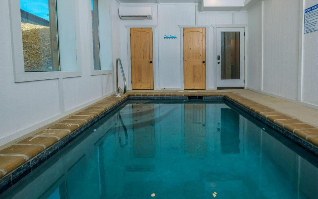 a swimming pool with blue water in a building at Smoky Mountain Oasis in Pigeon Forge