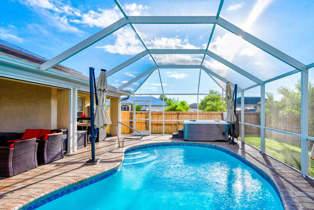einen Pool mit Glasdach auf einer Terrasse in der Unterkunft Four Bedrooms Oasis with Heated Pool Private Jacuzzi and Billiards in Cape Coral