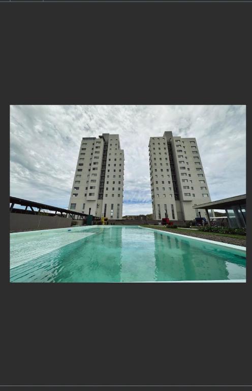 two tall buildings with a swimming pool in front of them at Torres al Mar in Monte Hermoso