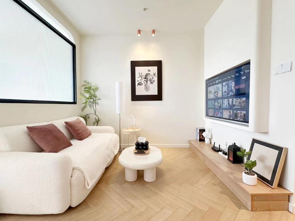 a living room with a white couch and a table at 同济佳苑公寓 in Shanghai