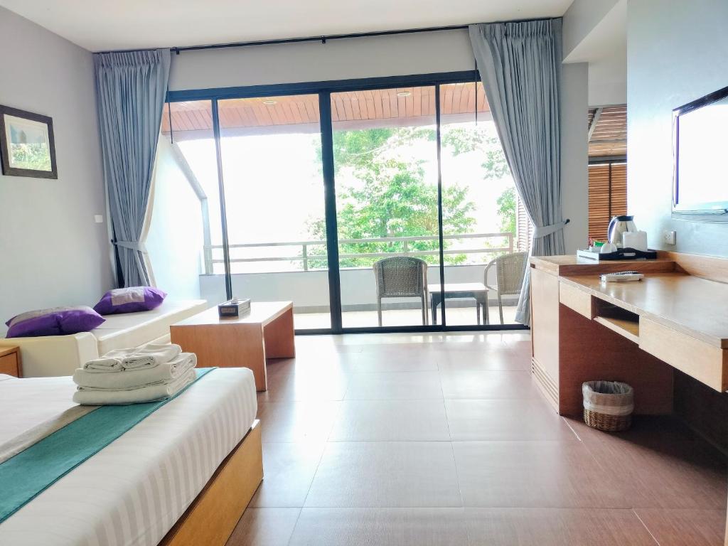 a hotel room with a bed and a large window at Chang Buri Resort & Koh Chang Hillside in Ko Chang