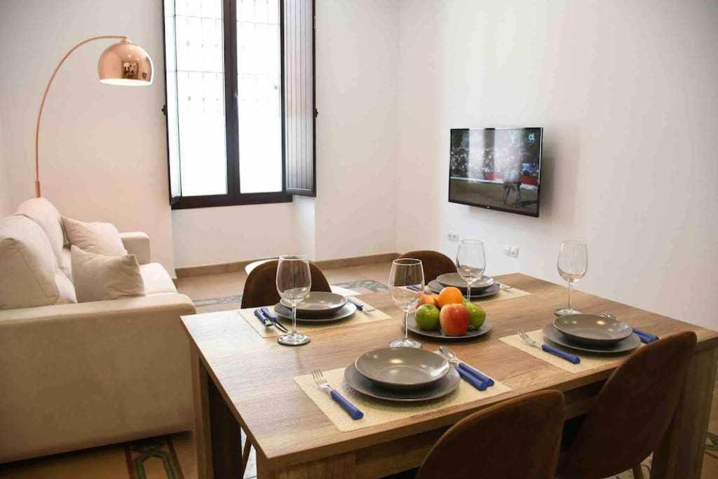 a dining room table with wine glasses and fruit on it at X C Apartamentos Morales & Arnal in Ronda