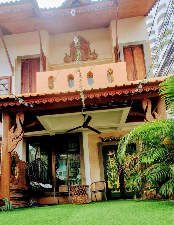 a house with a green lawn in front of it at Thai Authentic House in Jomtien Beach