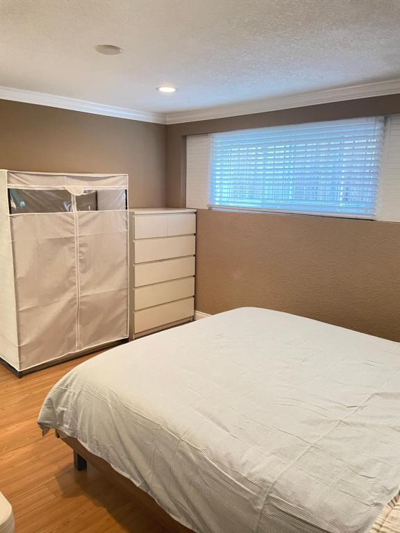 a bedroom with a bed and a window at Arbutus Jasmine room in Vancouver