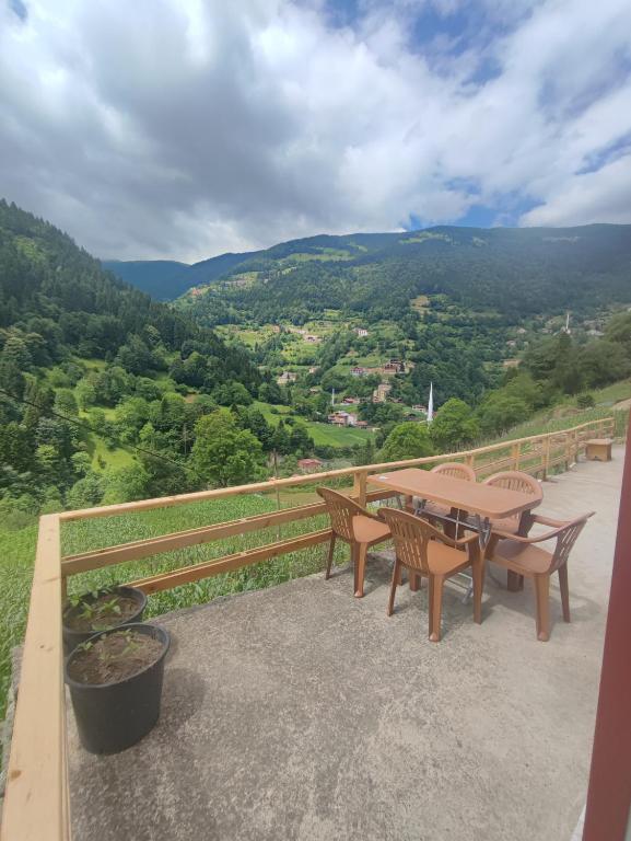 a table and chairs on a balcony with a view at AYDIN HOME Uzungöl in Uzungöl