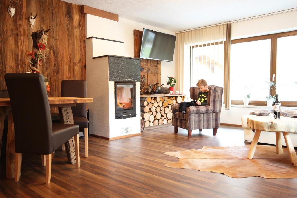 Apartment Ötztal في Tumpen: غرفة معيشة مع موقد وطاولة